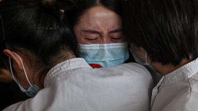 Medical staff from Jilin Province hug nurses from Wuhan after working together during the coronavirus outbreak, during a ceremony before leaving as Tianhe Airport is reopened. AFP