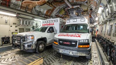 Two of the 12 ambulances destined for Gaza on board a military aircraft carrying humanitarian aid from Kuwait. Kuna / AFP