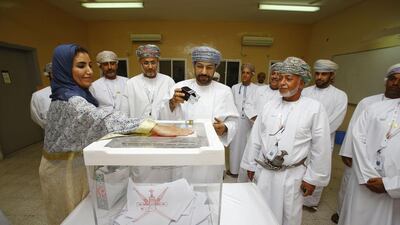 Omani interior minister Hamoud bin Faisal Al Busaidi (C) seals a ballot box at a polling station in Muscat for shura council elections on October 25. AFP Photo