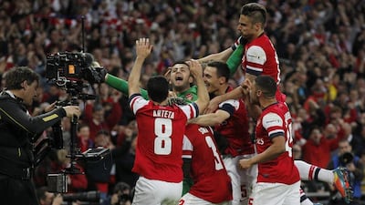 Arsenal players celebrate their win against Wigan Athletic at the end of their English FA Cup semifinal soccer match at Wembley Stadium in London, Saturday, April 12, 2014. AP Photo/Sang Tan