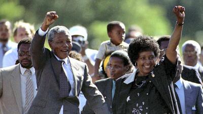 Nationalist leader Nelson Mandela (L) gestures as he is accompanied by his wife Winnie, moments after his release from Victor Verster prison in Western Cape in this February 11, 1990 file photo. Twenty years after Mandela was freed from prison, South Africa is a vibrant democracy but the millions still living in poverty are now looking for leadership that can tackle its economic problems. Mandela's release on Feb. 11, 1990, after 27 years in apartheid-era jails, set in motion the country's transformation to democracy which culminated in historic all-race elections in 1994 and his inauguration as the country's first black leader. REUTERS/Ulli Michel/Files (SOUTH AFRICA - Tags: POLITICS ANNIVERSARY)
