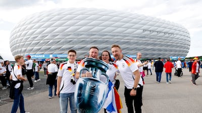 Fans pose in German shirts with an oversize trophy outside the stadium. Reuters