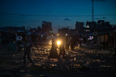 Palestinians at dusk during a power cut in Jabalia refugee camp in northern Gaza. EPA