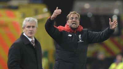 Liverpool's German manager Jurgen Klopp, right, gestures from the touchline next to Stoke City's Welsh manager Mark Hughes during the FA Cup semi-final first leg football match at Britannia Stadium in Stoke-on-Trent, central England, on January 5, 2015. AFP PHOTO / OLI SCARFF