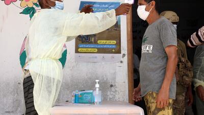 A Yemeni man has his temperature checked prior to being vaccinated. Once he receives a shot, he will be part of a tiny proportion in the conflict zone to have been inoculated against Covid. Photo: EPA