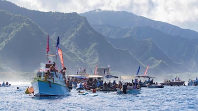 Spectators on boats watch as surfers compete. AFP