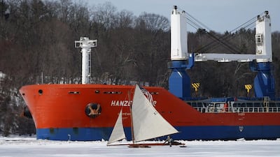 A sailboat from the Hudson River Ice Yacht Club’s sails across the ice as a ship passes through a channel in the ice. (Mike Segar / Reuters / March 7, 2014)