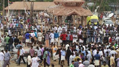 People gather inside the compound after a fire broke out at a temple in Kollam in the southern state of Kerala, India. A huge fire swept through a temple in India’s southern Kerala state early on Sunday, killing more than 100 80 people and injuring over 200 gathered for a fireworks display to mark the start of the local Hindu new year. Sivaram V / Reuters