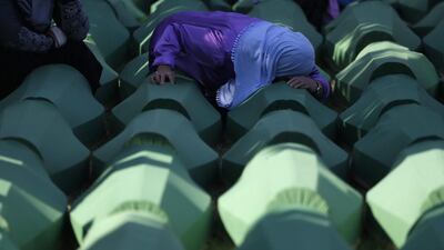 A Bosnian woman prays next to a coffin containing the remains of her relative perished in the Srebrenica massacre, during a funeral ceremony for the 127 victims at the Potocari memorial complex near Srebrenica, 150 kilometres northeast of Sarajevo, Bosnia and Herzegovina. Amel Emric / AP