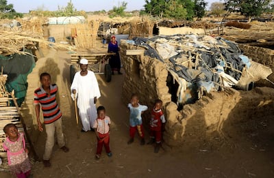 An internally displaced Sudanese family outside their makeshift shelter in Darfur, Sudan. Reuters