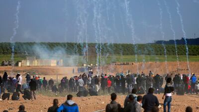 Teargas canisters fired by Israeli troops fall down on Palestinians during a demonstration in eastern Gaza City yesterday. Khalil Hamra / AP