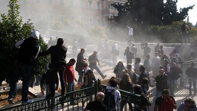 Riot policemen are seen amongst teargas during clashes with farmers during a rally in front of the Parliament, in Athens, Greece. Farmers are protesting against tax measures and changes in the social security system. Pantelis Saitas / EPA