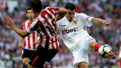 Sevilla's Alvaro Negredo, right, shoots as Bilbao's Carlos Gurpegui attempts a block.