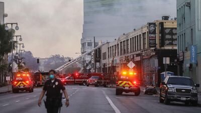 An LAPD officer keeps watch on a multiple structure fire as LAFD firefighters work following an explosion in Los Angeles, California. AFP