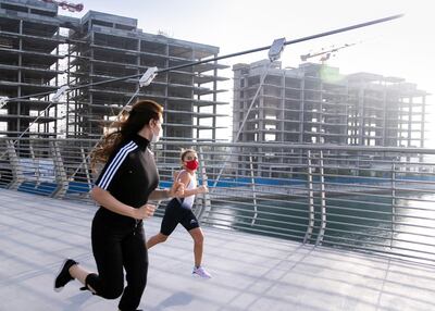 Afra Al Majar and Asma Al Janahi run along the Dubai Canal. Reem Mohammed / The National