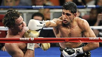 Amir Khan, right, showed a dominant performance to beat local favourite Paulie Malignaggi at Madison Square Garden, New York.