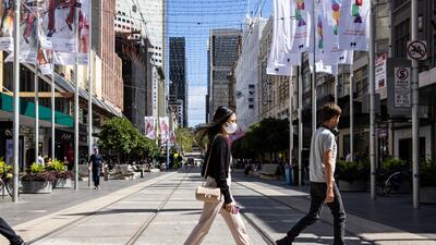 A woman wearing a face mask crosses Bourke Street in Melbourne, Australia. The country's leaders want to move to living with coronavirus as though it were the flu, according to Prime Minister Scott Morrison. EPA