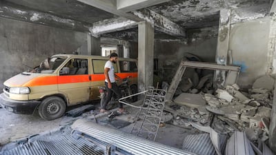 A man walks past a damaged mini-van that was used as a make-shift ambulance amidst debris in the garage of a hospital damaged after a reported air strike in Jisr Al Shughur in the northeastern Syrian Idlib province on July 10, 2019. AFP