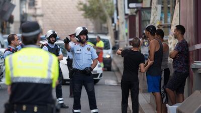Police officers check the identity of a group of men on Las Ramblas. Carl Court / Getty Images