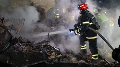 Ukrainian rescuers working at the scene of a drone attack in Kharkiv late on Thursday. Britain and France say Russia is dragging its feet on a ceasefire. EPA