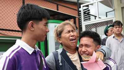 Pupils are embraced by loved ones after fleeing the school. Reuters