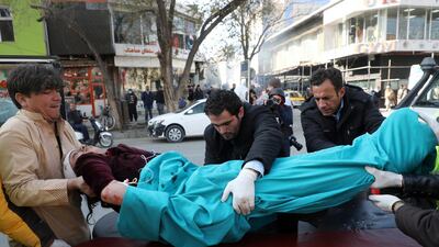 Men carry an injured person to a hospital after rockets hit residential areas in Kabul, Afghanistan. REUTERS