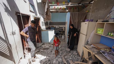 A Palestinian family search the rubble of their home after it was hit in a dawn strike by Israeli forces, in Nuseirat city, central Gaza. AFP