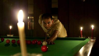 An Egyptian man plays snooker by candlelight at a club in Giza in this 2013 photo. The government has been raising funds to solve Egypt’s electricity shortages. Hassan Ammar / AP Photo
