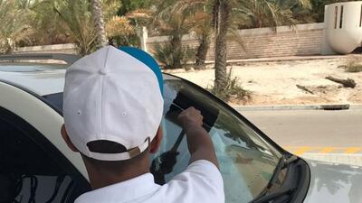 One of the six men works at petrol station after being ordered to carry out community service for reckless driving. Courtesy Abu Dhabi Judicial Department