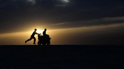 An Afghan youth pushes a friend on a ice-cream cart, as the sun sets on the outskirts of Mazar-I- Sharif. Farshad Usyan / AFP