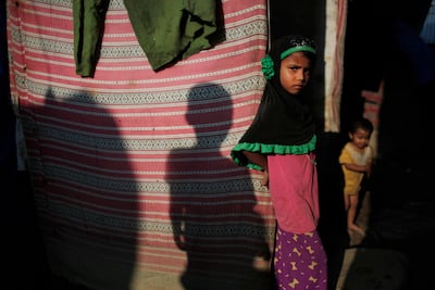 A young Rohingya girl stands outside her temporary shelter at a camp in Kathmandu, Nepal. Niranjan Shrestha / AP Photo