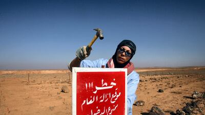 A Jordanian woman alerting people to a de-mining zone. AFP