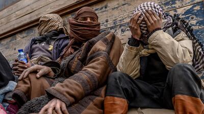 Men suspected of being ISIS fighters wait to be screened by members of the Kurdish-led SDF after leaving Baghouz, in Syria's northern Deir Ezzor. AFP