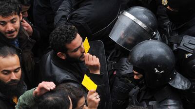 Tunisian protesters confront security forces yesterday. Sofiene Hamdaoui / AFP