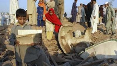 Children collect stationery from the debris of a girls' school after it was bombed by militants in Pakistan's Khyber tribal region yesterday.