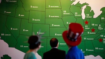 People watch the electoral college map as the votes are counted. Mr Obama appears to now be headed towards victories in the northeast.