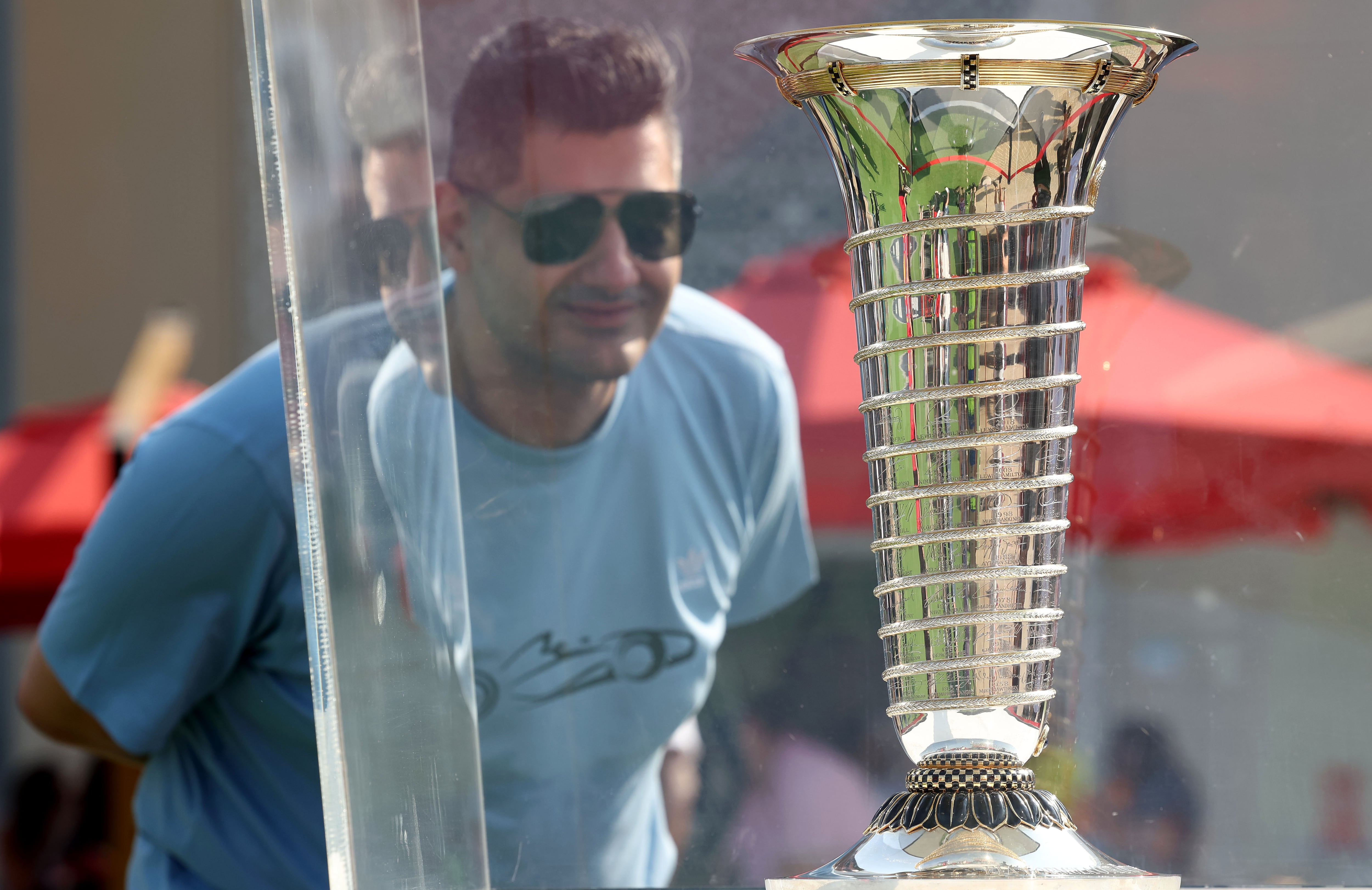 A fan looks at the world championship trophy at Yas Marina Circuit