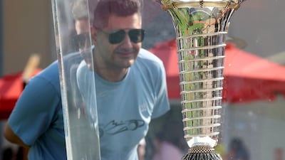 A fan looks at the world championship trophy at Yas Marina Circuit