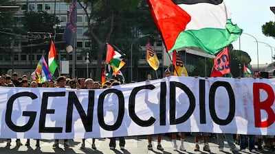 People march behind a banner that reads 'Against Genocide Let's block everything', in Rome. AFP