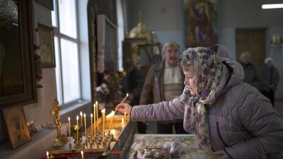 A woman lights a candle before a service in the St Olga and St Vladimir Cathedral in Simferopol, Crimea.The property has come under threat from Crimea’s pro-Moscow leaders, who have hiked up the rent and are threatening to take the property from the church. Alexander Zemlianichenko / AP Photo