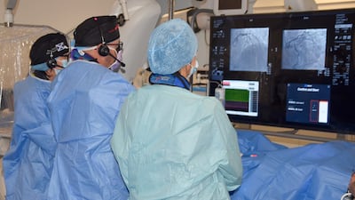 Specialists at the Golden Jubilee University National Hospital in Clydebank, western Scotland, analyse images during an operation as part of a live trial using Ultreon 1.0 Software. Artificial intelligence is being used to help provide life-saving operations for heart patients. PA