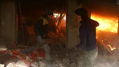 Rescuers race through the rubble of a building set on fire by Syrian government air strikes on Douma on February 7, 2018. Bassam Khabieh / Reuters