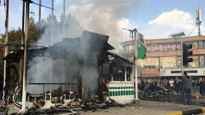 Iranians gather around a smouldering police station that was set ablaze by protesters during a demonstration against a rise in petrol prices in the central city of Isfahan on November 17, 2019. AFP