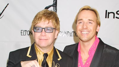Elton John, in a black suit with gold embellishment and a gold shirt, and David Furnish arrive at the Elton John post-Oscars party on March 25, 2001 at Moomba restaurant in West Hollywood. Getty Images