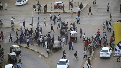 People gather outside the headquarters of the Directorate of General Intelligence Service in Khartoum after members of Sudan's intelligence services shot bullets in the air, in the Riyadh district of the capital. AFP