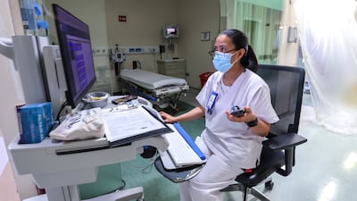 An ER medical worker reviews charts while on standby for incoming emergency patients