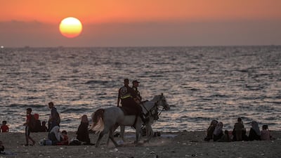 Palestinian families enjoy their time at the beach amid the ongoing Covid-19 pandemic in Gaza City. EPA