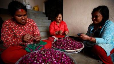 Women work to make garland from the globe amaranth flowers, before selling them to the market for the Tihar festival, also called Diwali, in Bhaktapur, Nepal October 21, 2019. Reuters