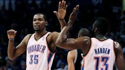 Kevin Durant, left, celebrates with teammate James Harden in Oklahoma City's 109-103 series-evening win.