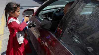 A girl sells protective face masks and gloves at the main market in downtown after the government eased the restrictions on movement aimed at containing the spread of the coronavirus disease, in Amman, Jordan. Reuters